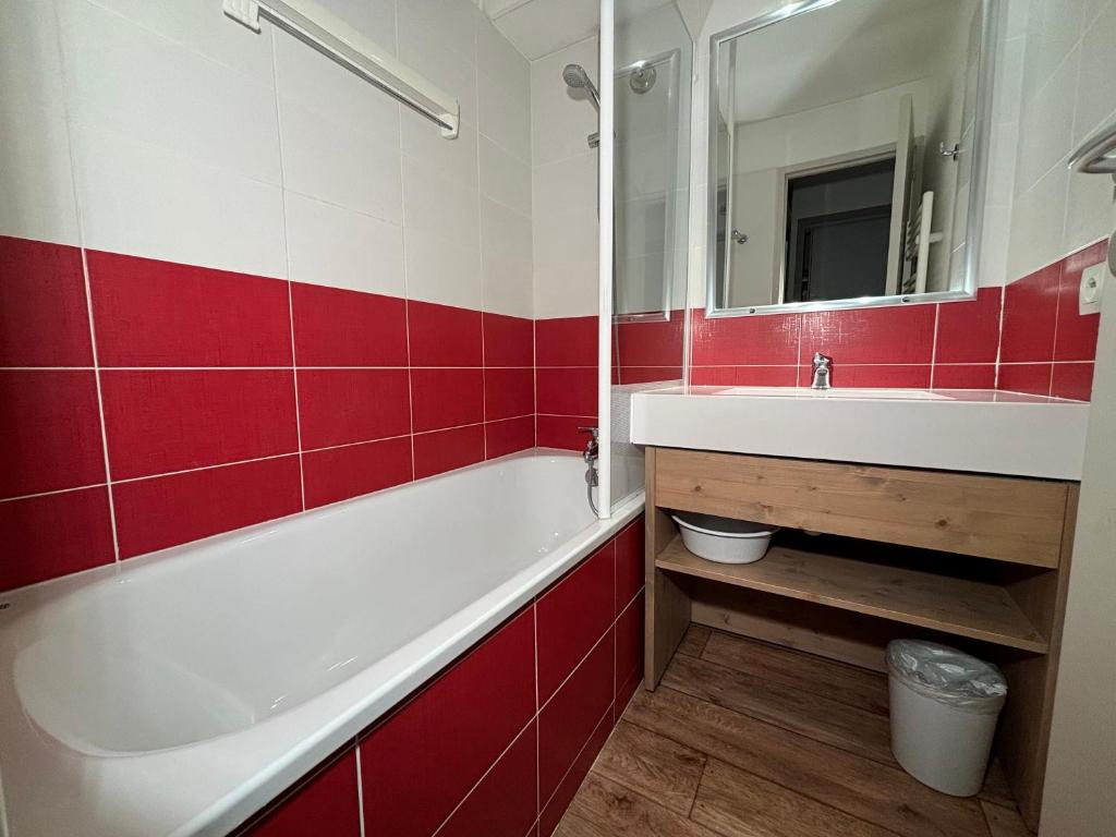 une salle de bain avec une baignoire, un lavabo et un miroir dans l'établissement Résidence Britania Clés Blanches, à La Tania 25 autres photos