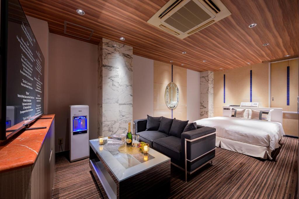 une chambre d'hôtel avec un lit et un canapé dans l'établissement コスタリゾート茅ヶ崎大人専用, à Suka 111 autres photos