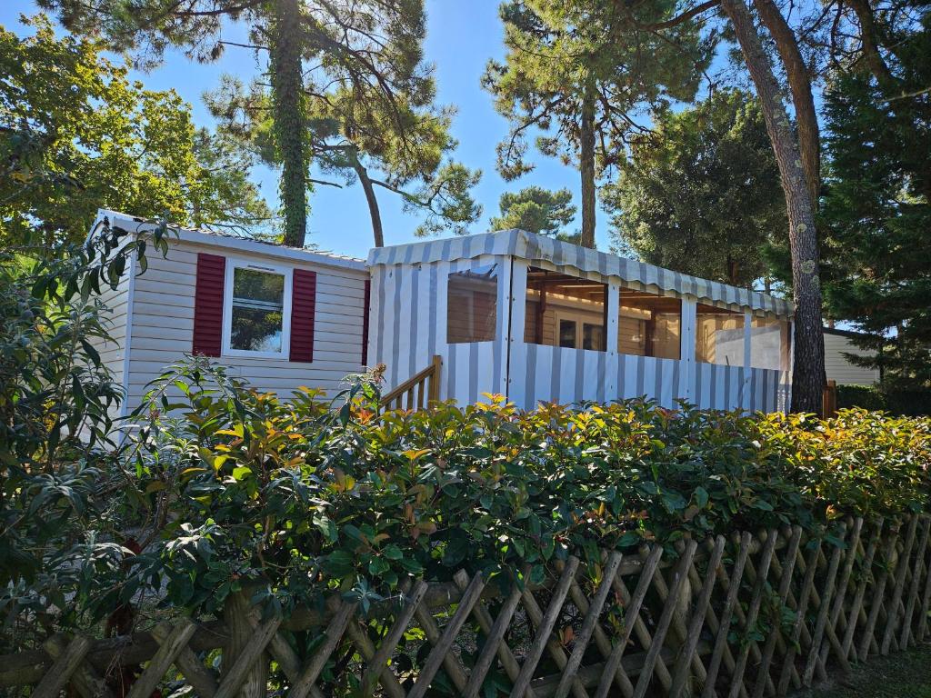 une petite maison dans un jardin avec une clôture dans l'établissement Location mobil-home, à Saint-Jean-de-Monts