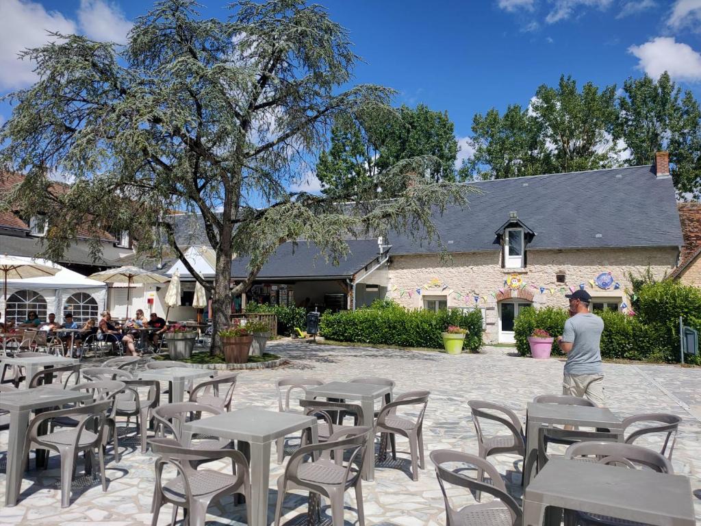 un groupe de tables et de chaises devant un bâtiment dans l'établissement Nat & Mayou, à Onzain