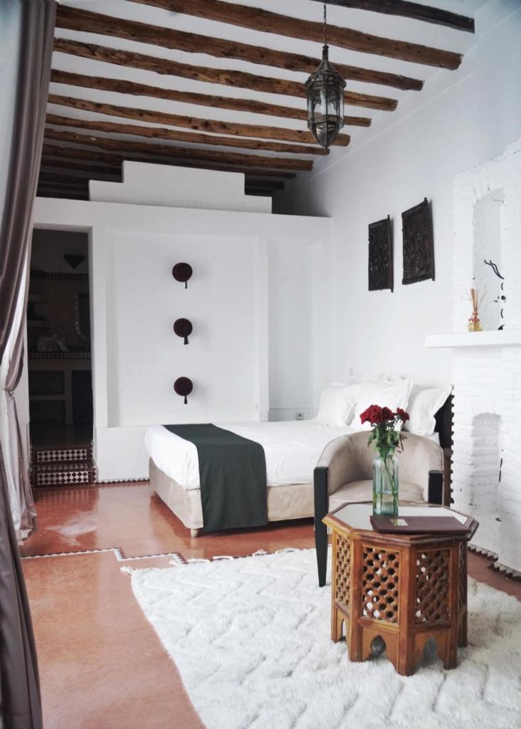 une chambre blanche avec un lit et une table dans l'établissement Riad Twilight, à Marrakech