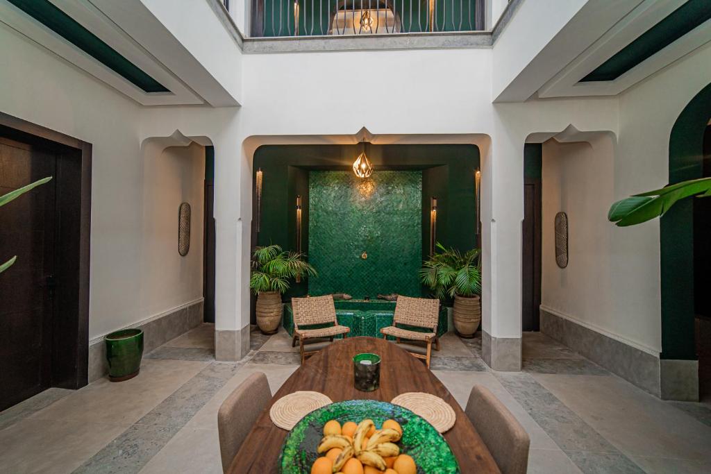 une salle à manger avec une table avec des fruits dessus dans l'établissement Riad Sabrawa, à Marrakech