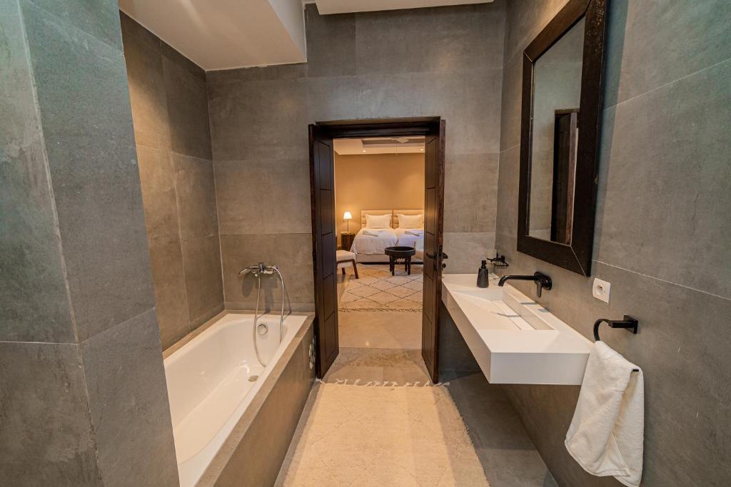 une salle de bain avec deux lavabos et une baignoire dans l'établissement Riad Sabrawa, à Marrakech