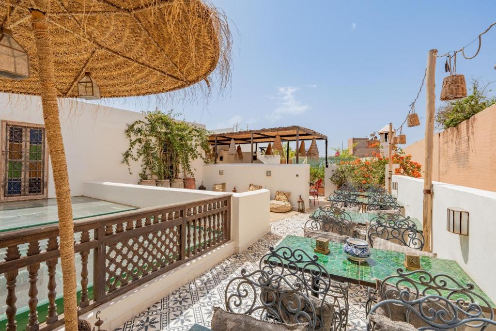 un patio avec tables, chaises et un parasol dans l'établissement Riad Yamina52, à Marrakech