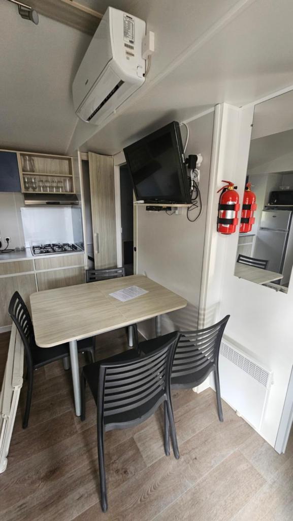 - une table à manger et 2 chaises dans la cuisine dans l'établissement Charmant mobil-home cosy 168, à Narbonne