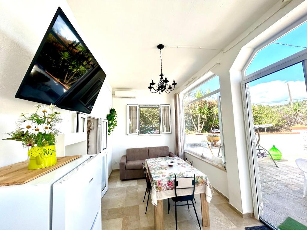 Elle comprend un petit salon avec une table et une télévision. dans l'établissement Trullo Simona - Luxury Relax House, à Ostuni