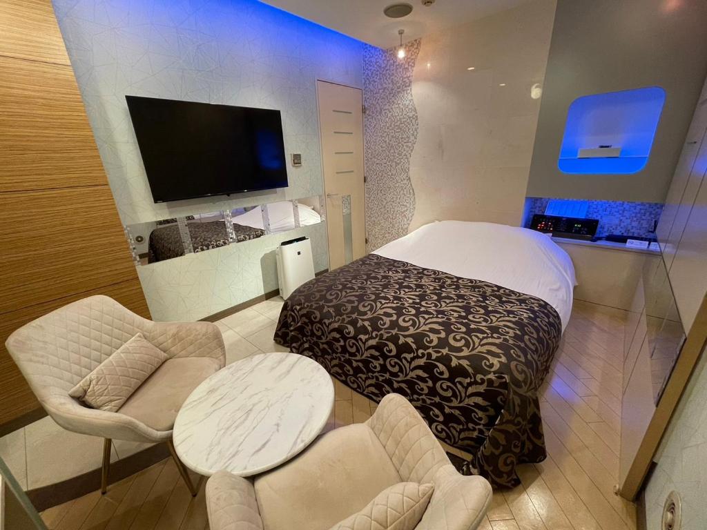 un salon avec une télévision et quelques chaises dans l'établissement Hotel THE ATTA Adult Only, à Tokyo