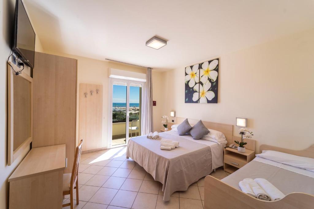 une chambre d'hôtel avec un lit et une télévision dans l'établissement Melody Hotel, à Cervia