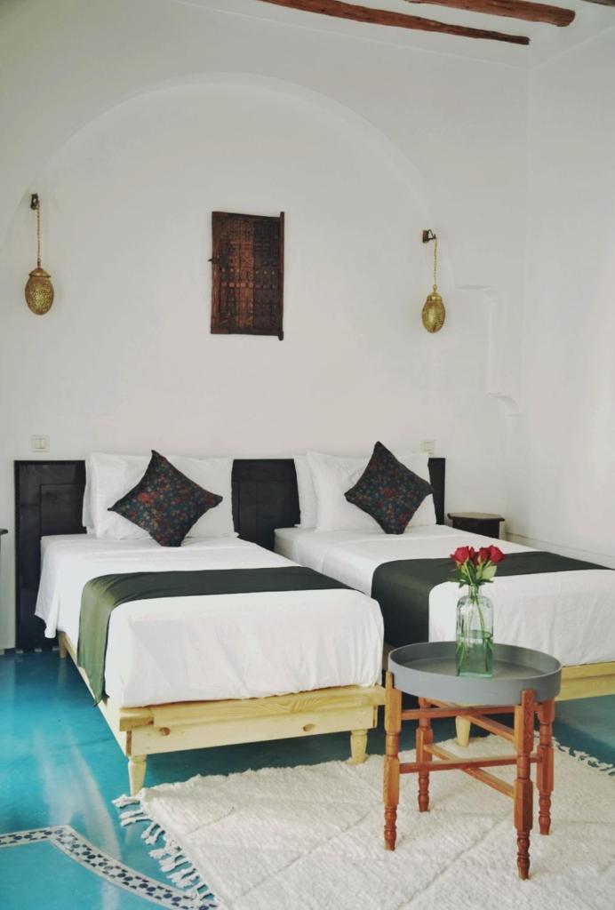 - 2 lits dans une chambre avec une table dans l'établissement Riad Twilight, à Marrakech