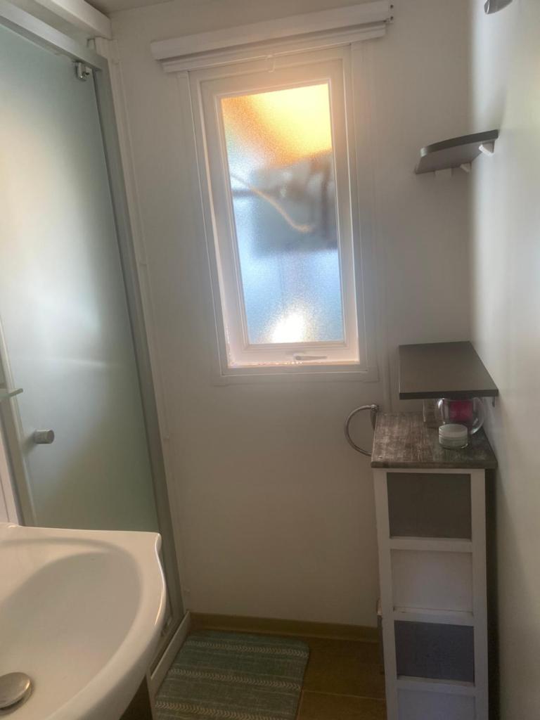 une salle de bain avec un lavabo et une fenêtre dans l'établissement Oasis de détente, à Fréjus