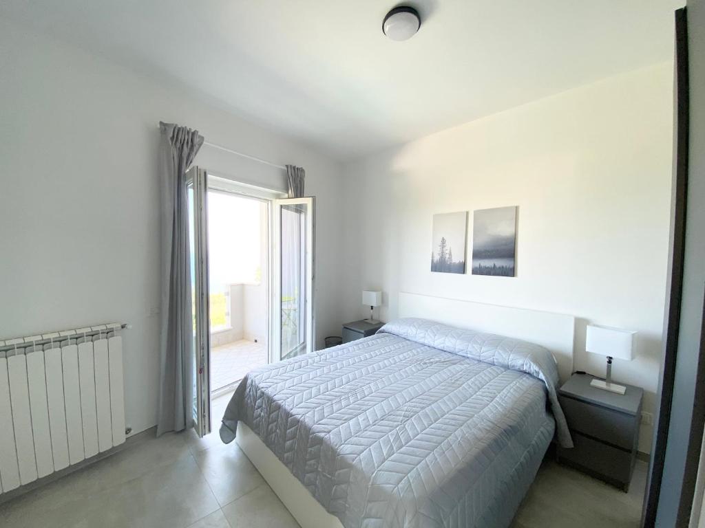 une chambre blanche avec un lit et une fenêtre dans l'établissement Stunning sea view villa, à Briatico 31 autres photos