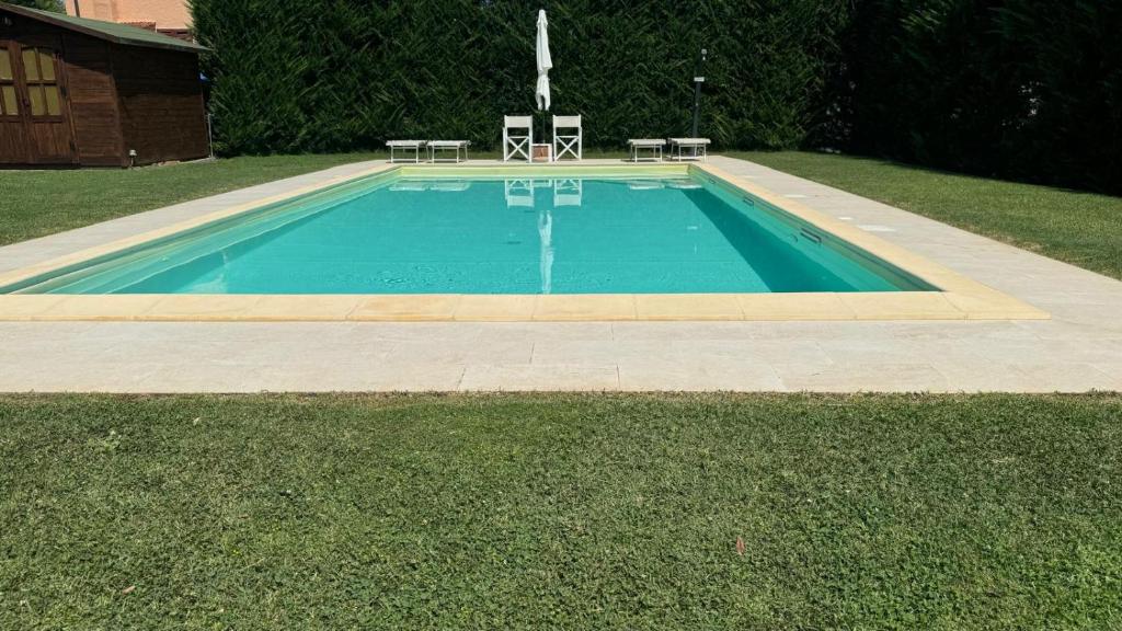une piscine avec deux chaises et une table dans l'établissement Villa Cristina modern farmhouse with Private Pool, à Monsagrati