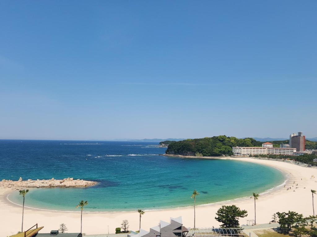 une vue sur une plage avec des palmiers et l'océan dans l'établissement Hotel Sanrakuso, à Shirahama