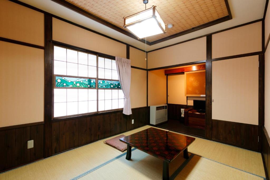 un salon avec une table et une fenêtre dans l'établissement Tsuyukusa, à Takayama