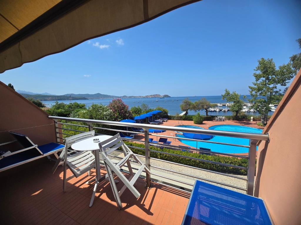 un balcon avec une table, des chaises et un bateau dans l'établissement Hotel Mare, à Portoferraio