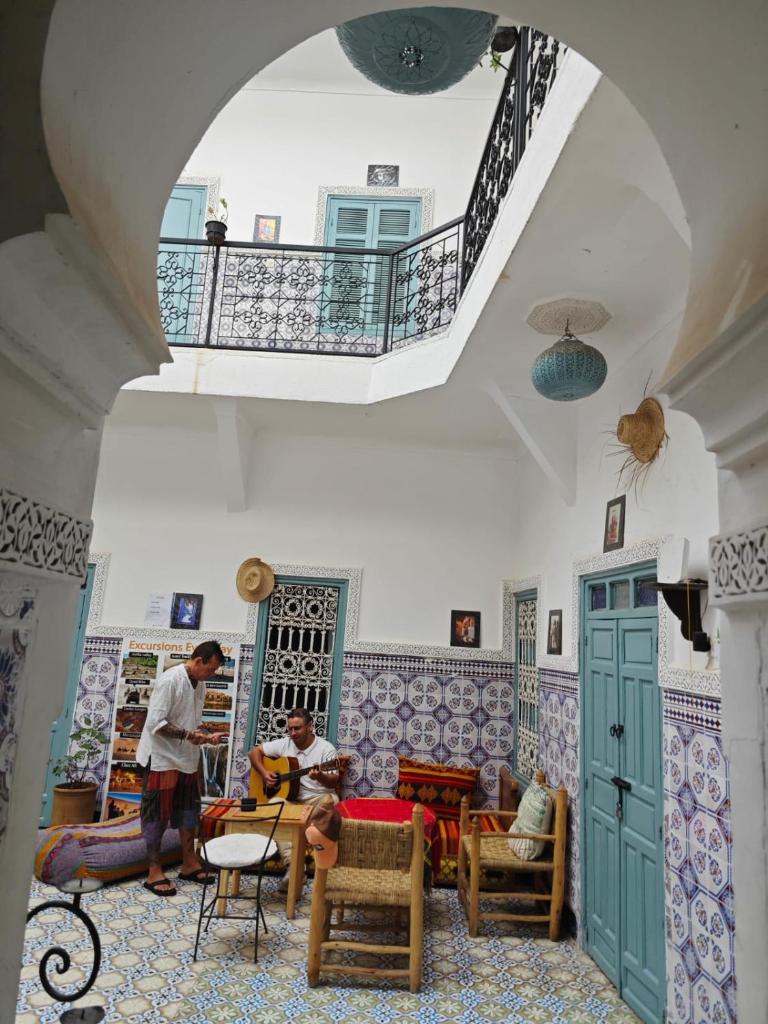 une chambre avec deux personnes assises dans une pièce dans l'établissement Hostel BE 20, à Marrakech