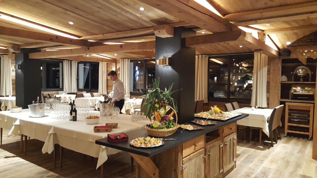 une salle à manger avec des tables et une personne en arrière-plan dans l'établissement Hôtel Le Sporting, à Morzine