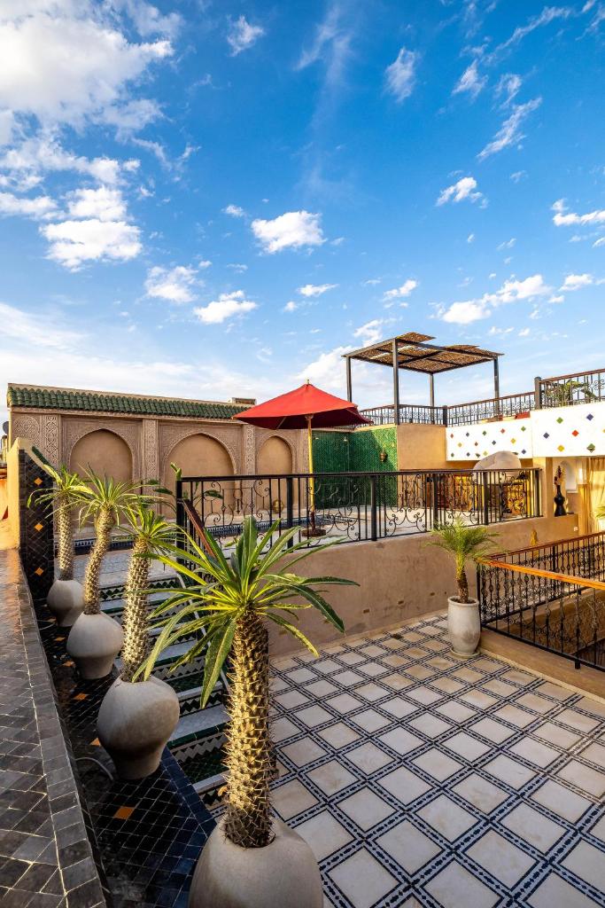un patio avec des palmiers et un bâtiment avec un toit dans l'établissement Riad Hamdane et SPA, à Marrakech