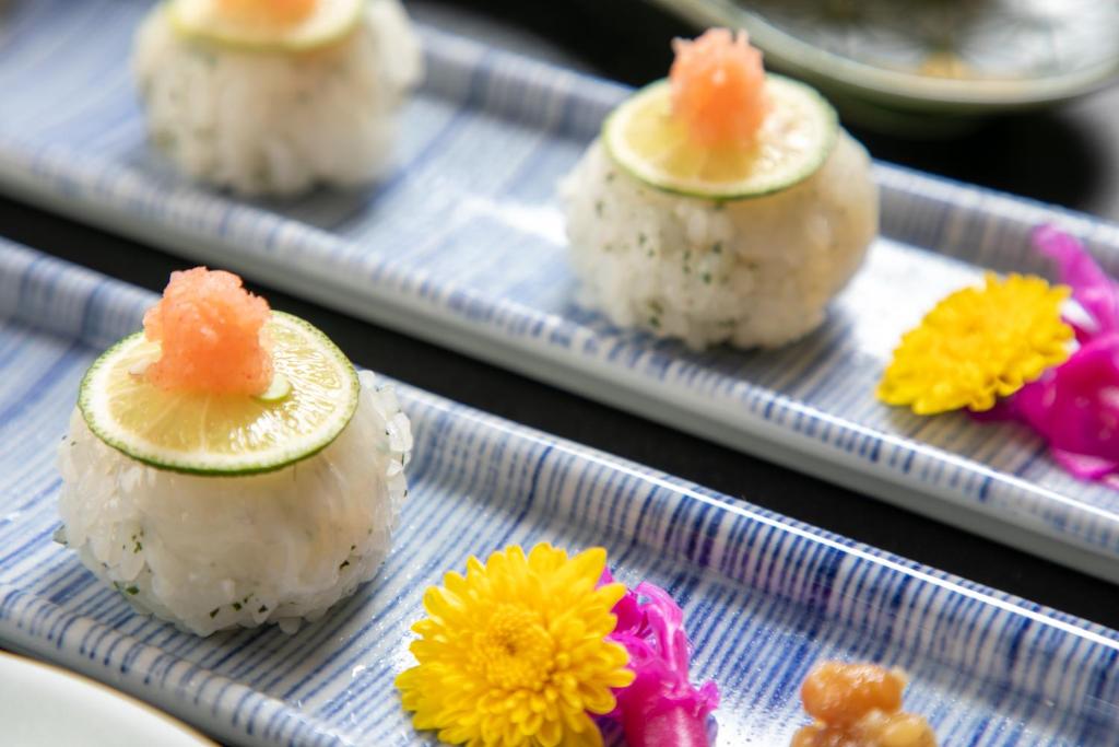 Une rangée de sushis sur des assiettes avec des fleurs sur elles dans l'établissement Wakamatsuya, à Zao Onsen