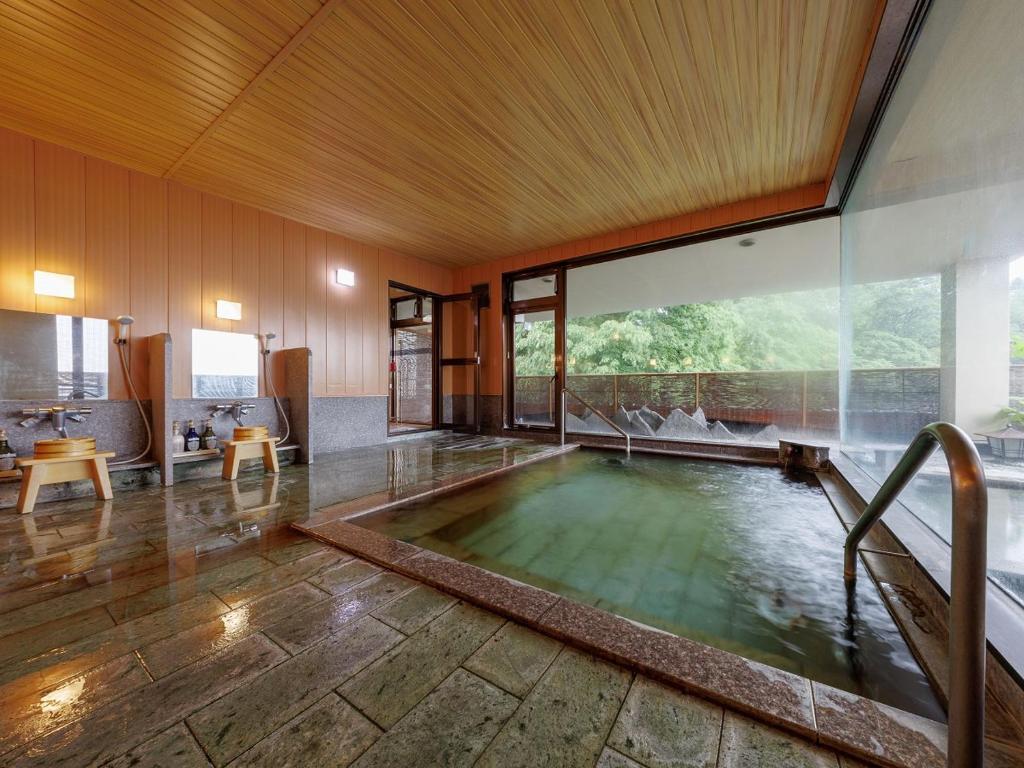 - une piscine au milieu d'une chambre avec une grande fenêtre dans l'établissement Chousenkaku Kameya, à Shimo-suwa
