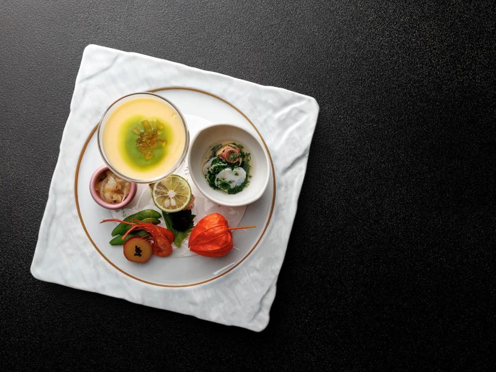 une assiette de nourriture avec soupe et légumes sur une serviette dans l'établissement Chousenkaku Kameya, à Shimo-suwa