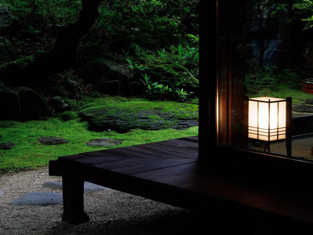 une lampe assise sur un banc devant une fenêtre dans l'établissement Chousenkaku Kameya, à Shimo-suwa