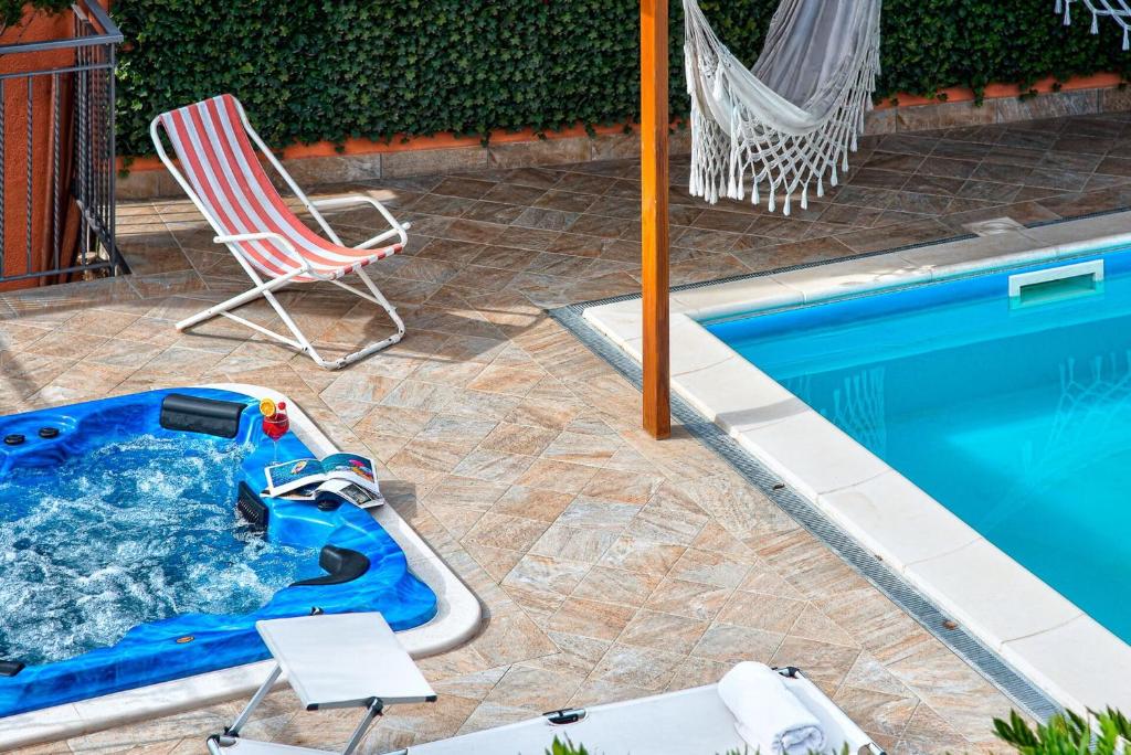 une chaise et un parasol à côté de la piscine dans l'établissement Villa Sorrentina With Panoramic Terrace, à Massa Lubrense 20 autres photos