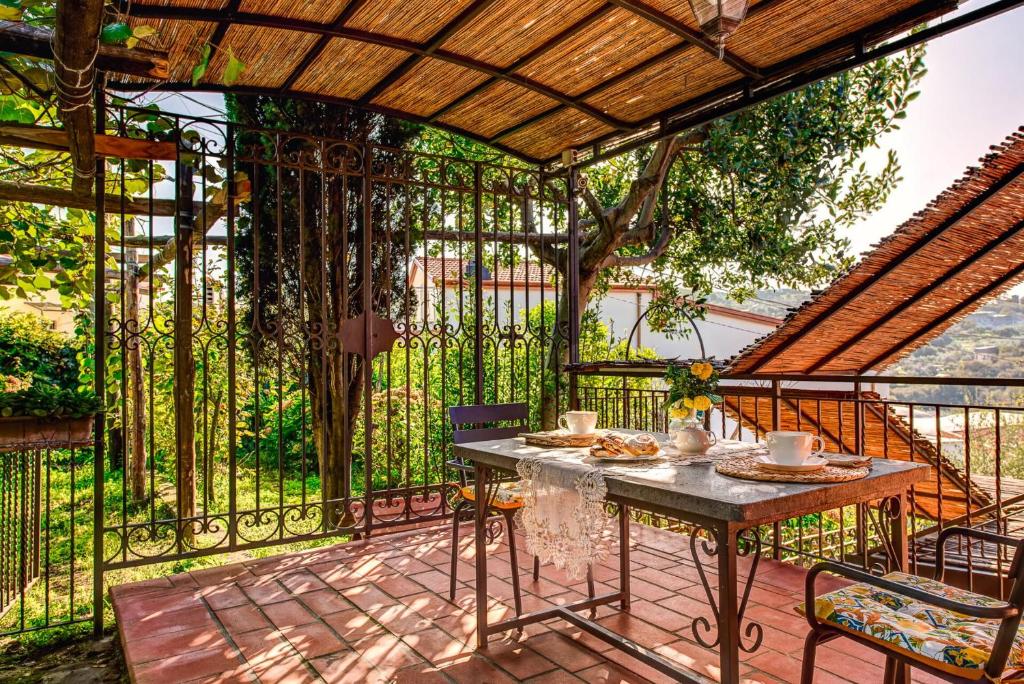 un patio avec une table et des chaises et une clôture dans l'établissement Villa Sorrentina With Panoramic Terrace, à Massa Lubrense