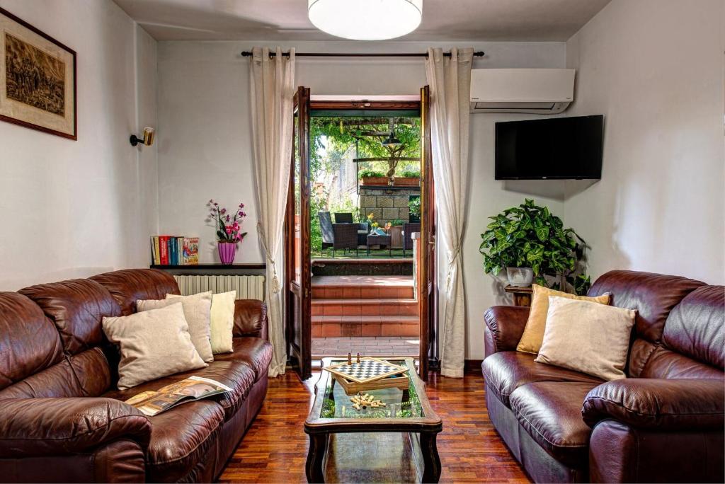 - un salon avec des canapés en cuir brun et une table dans l'établissement Villa Sorrentina With Panoramic Terrace, à Massa Lubrense