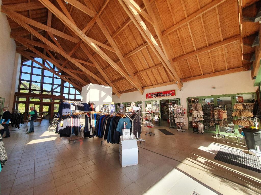 un magasin avec une grande pièce dotée de portants dans l'établissement Chez Virginie cocon familial, à Ustou