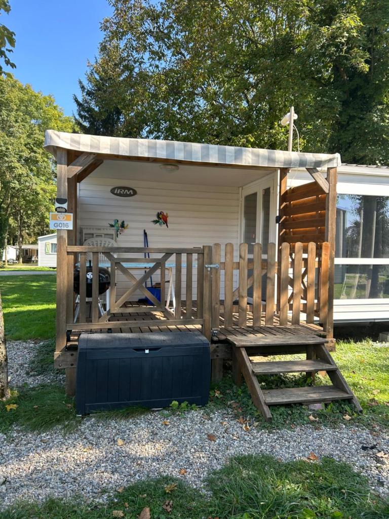 une petite maison avec un porche, une table et un banc dans l'établissement Chez Nathalie mobil home chauffé et climatisé, à Boofzheim