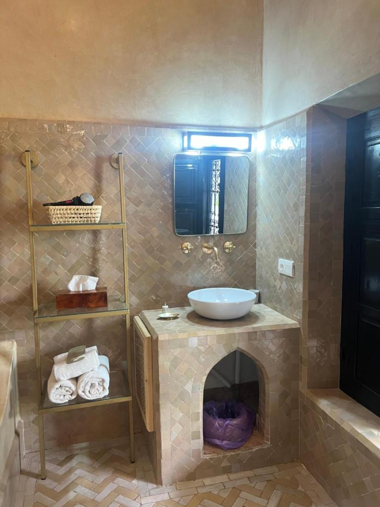 une salle de bain avec un lavabo et un miroir dans l'établissement Riad Ajmal, à Marrakech