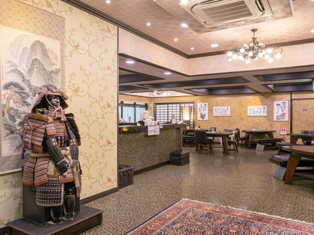 un restaurant avec une statue au milieu d'une pièce dans l'établissement Yufuin Besso Shikisai Hotel, à Yufu