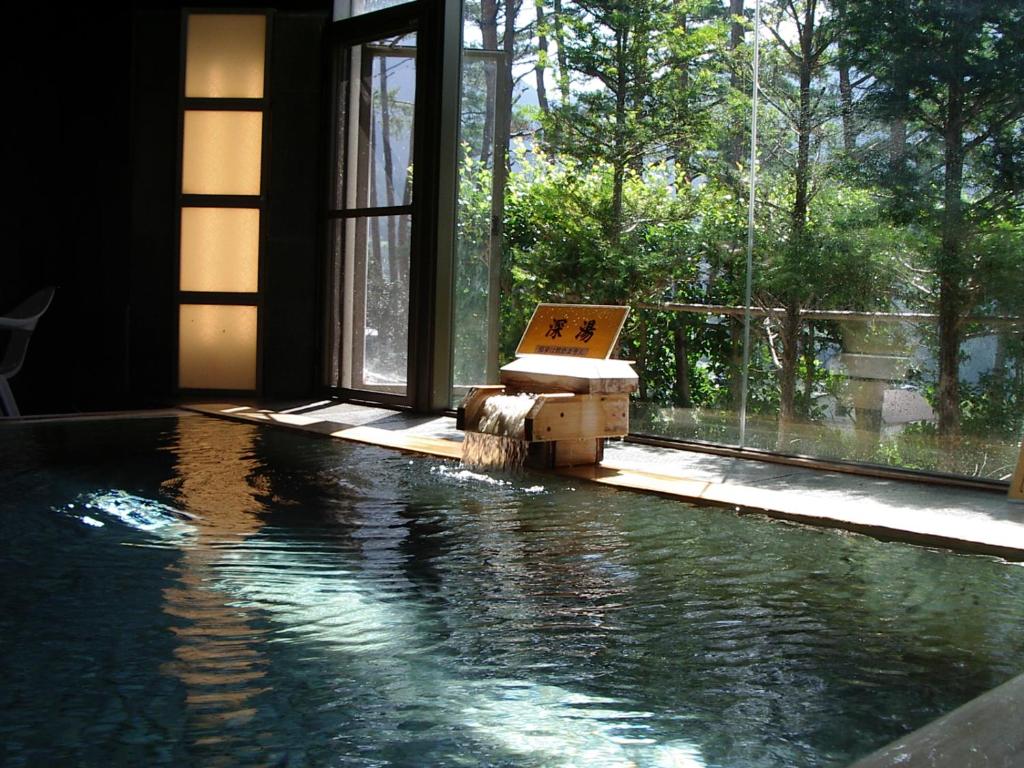 - une piscine avec un panneau dans l'eau dans l'établissement Hotel Miki, à Gero