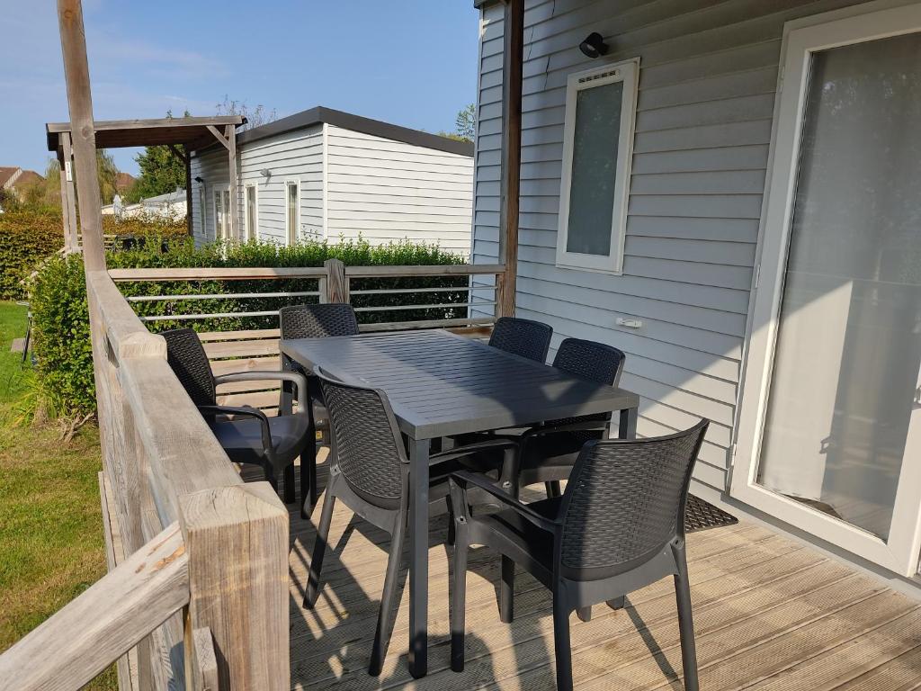 une table et des chaises noires sur une terrasse dans l'établissement Mobil home Houlgate, à Houlgate