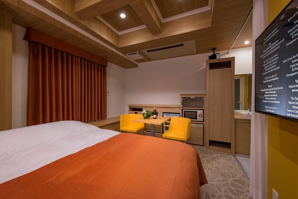 Cette chambre comprend un lit, une table et des chaises jaunes. dans l'établissement Hotel Eldia Luxury Sendai -Adult Only, à Moniwa