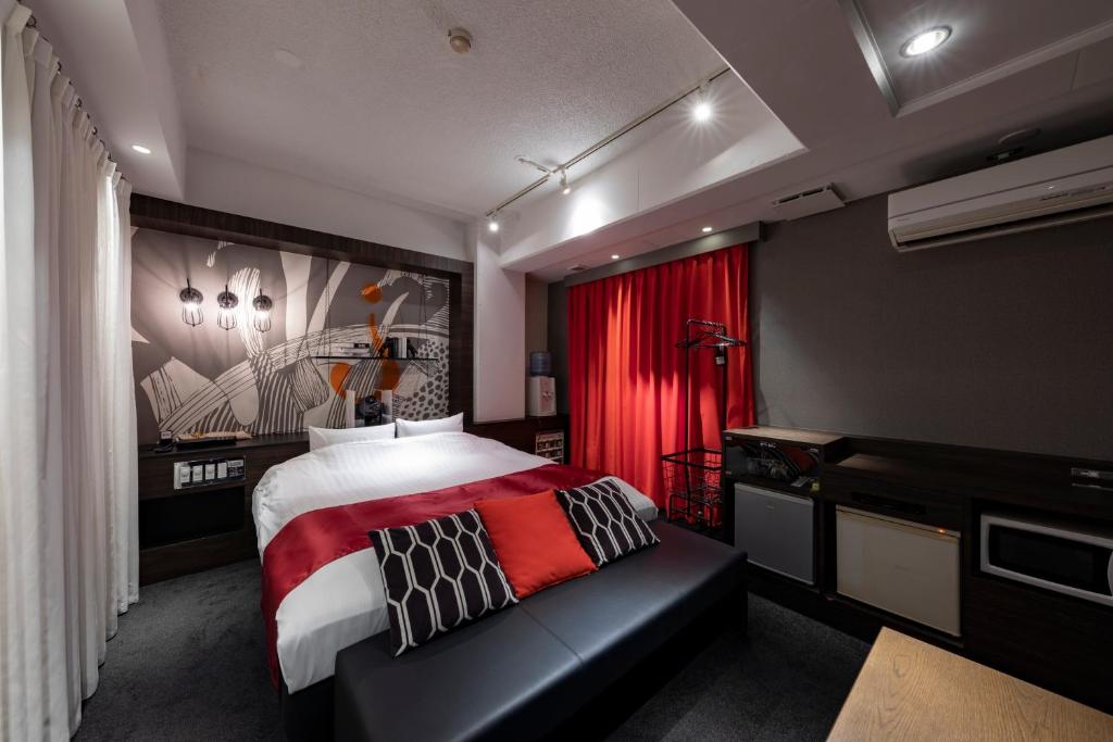 une chambre avec un lit et un rideau rouge dans l'établissement Hotel Eldia Modern Sendai -Adult Only, à Ayashi