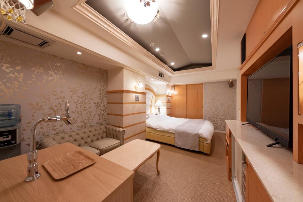 une chambre d'hôtel avec un lit et une télévision dans l'établissement Hotel Luna Sendai -Adult Only, à Shimo-ayashi