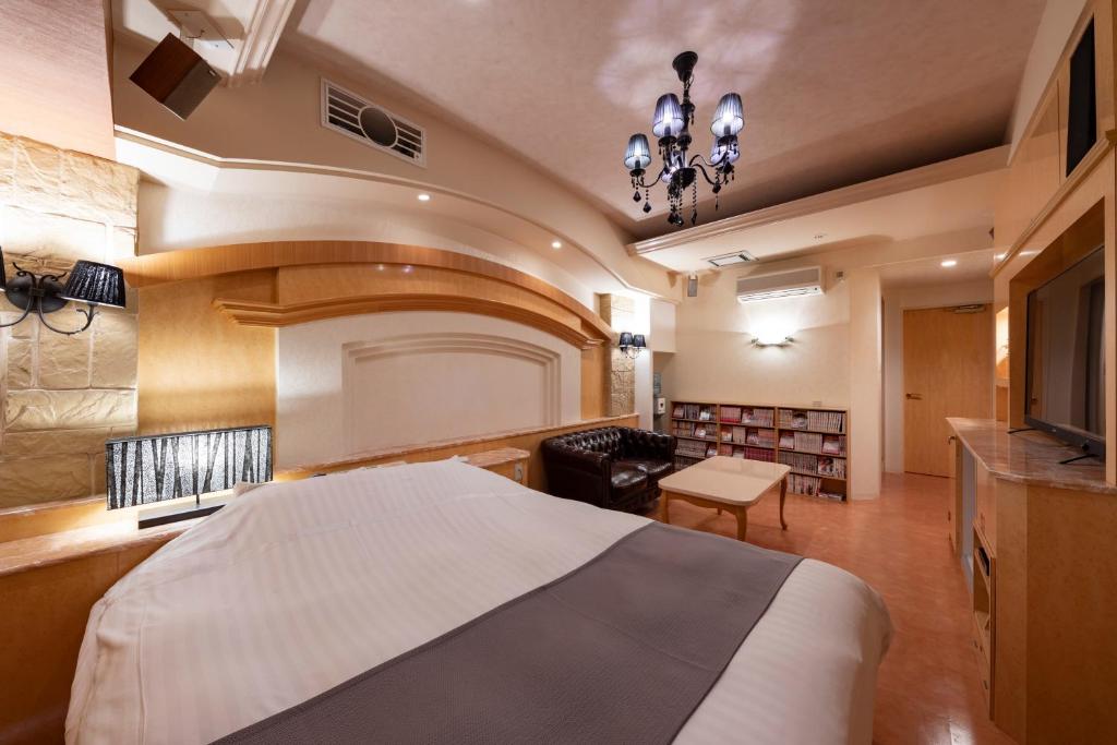 une chambre avec un grand lit et un salon dans l'établissement Hotel Luna Sendai -Adult Only, à Shimo-ayashi
