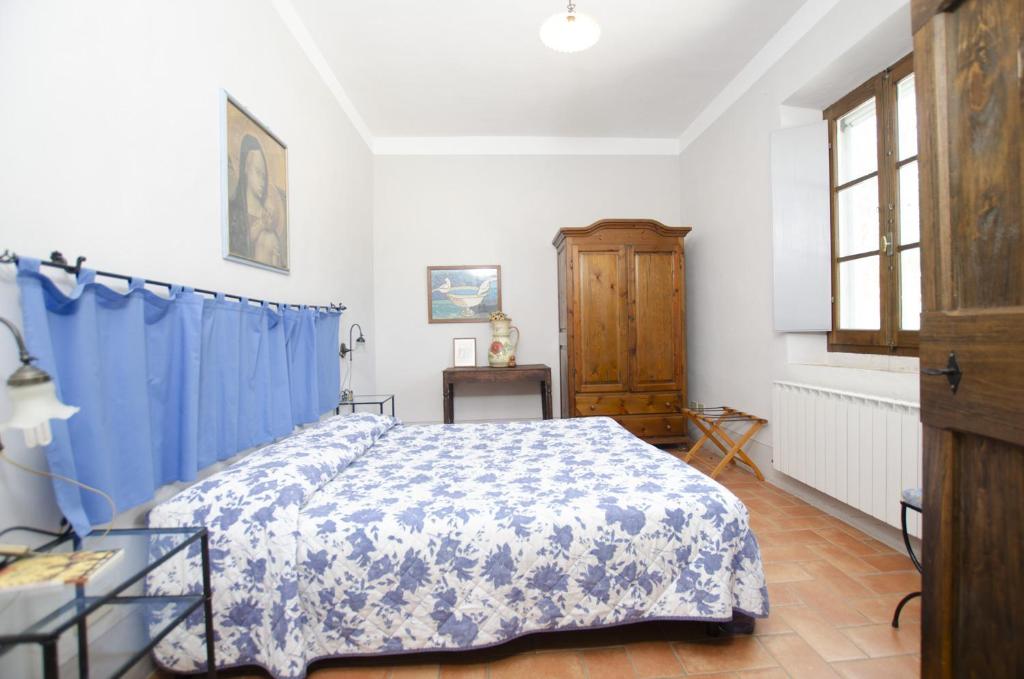 une chambre avec un lit et un rideau bleu dans l'établissement Casale del Conte, à Pienza 15 autres photos