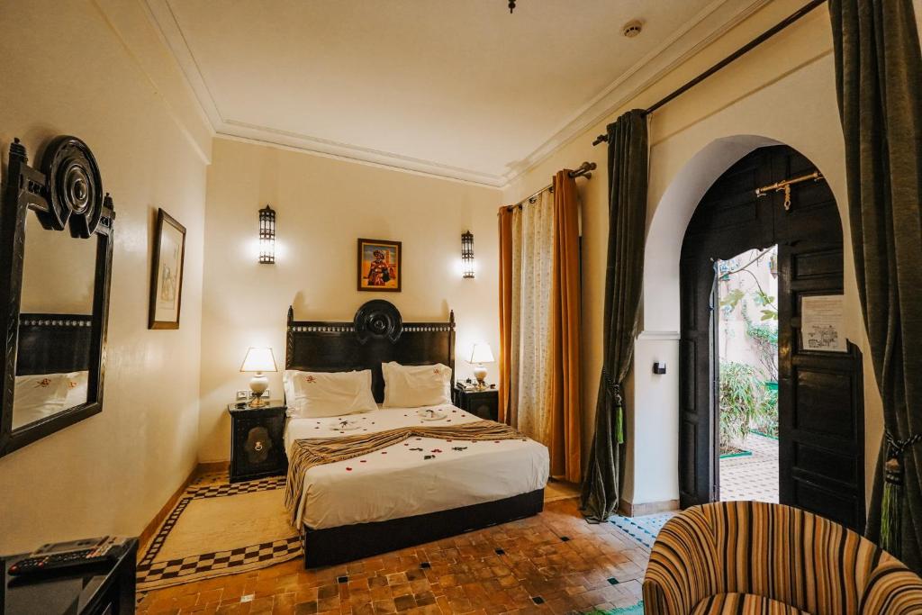 une chambre avec un lit et une porte ouverte dans l'établissement Les Borjs De La Kasbah, à Marrakech