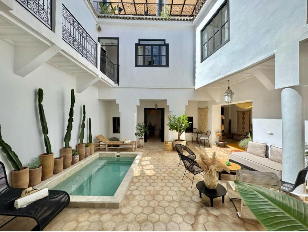 - un grand salon avec une piscine dans une maison dans l'établissement Riad 27 & SPA entièrement privatisé, à Marrakech