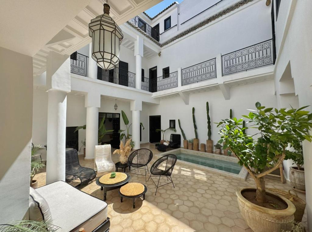 - un salon avec une piscine dans une maison dans l'établissement Riad 27 & SPA entièrement privatisé, à Marrakech
