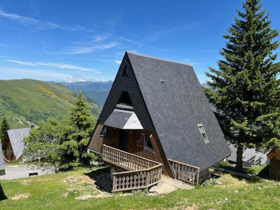 une maison avec un toit noir au sommet d'une colline dans l'établissement Chalet 6-9 pers St Lary Alt1700m -100mdespistes classé 4 étoiles, à Saint-Lary-Soulan