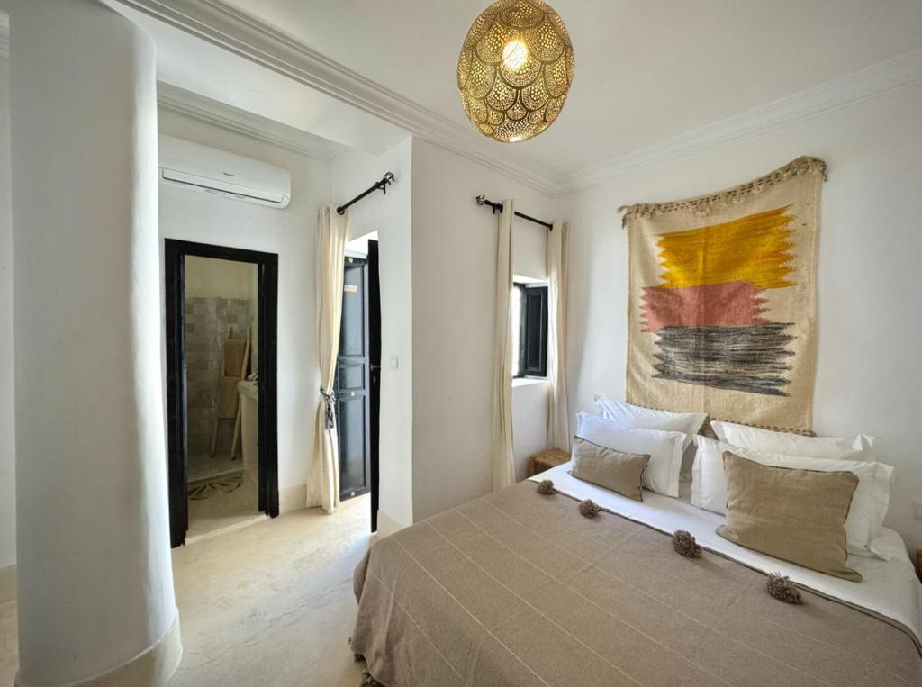 une chambre avec un lit et un tableau au mur dans l'établissement Riad 27 & SPA entièrement privatisé, à Marrakech