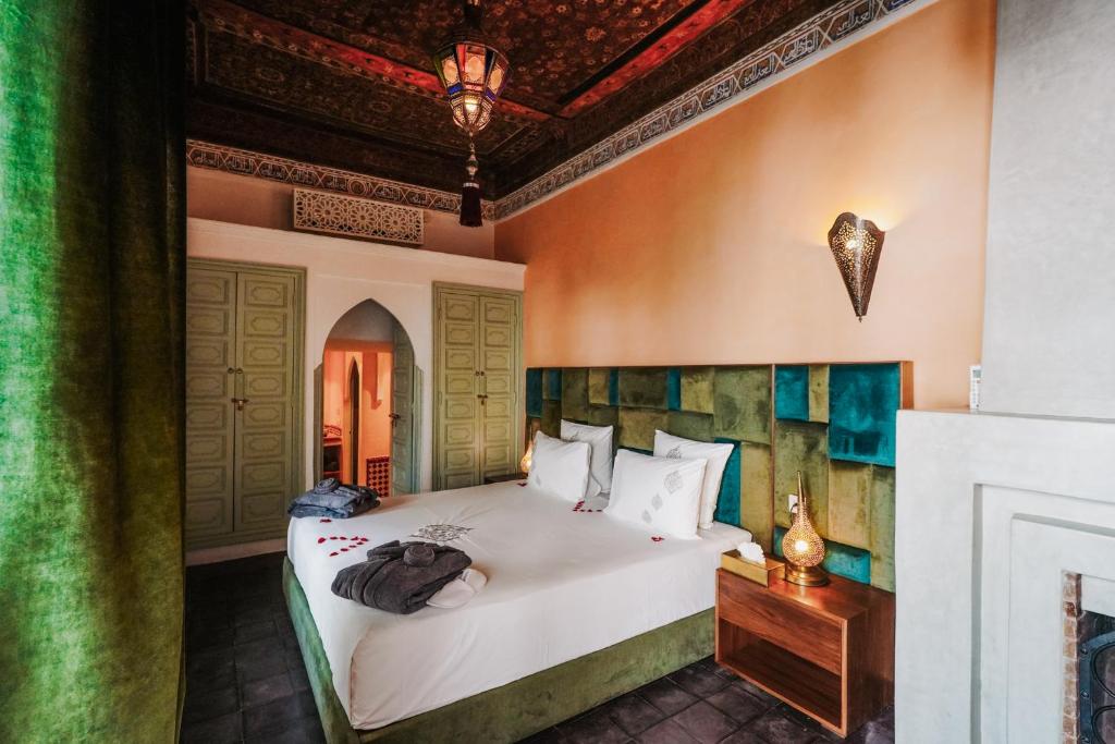 une chambre avec un grand lit blanc dans une pièce dans l'établissement Riad Assouel et Spa By La Siredrah, à Marrakech
