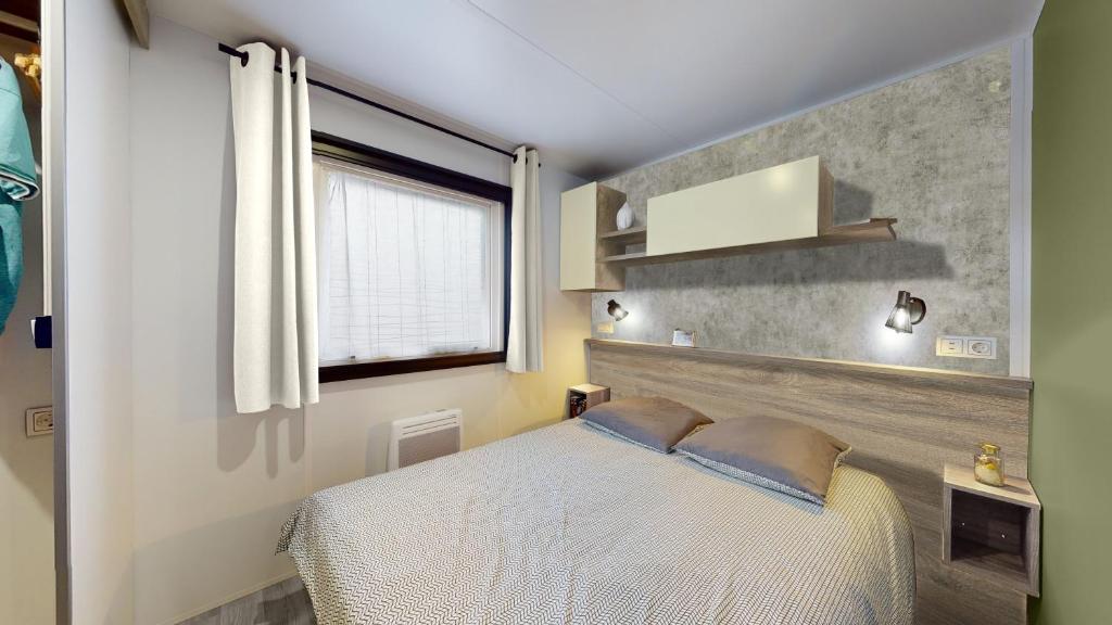 une chambre avec un lit et une fenêtre dans l'établissement mobilhome neuf, à Piriac-sur-Mer