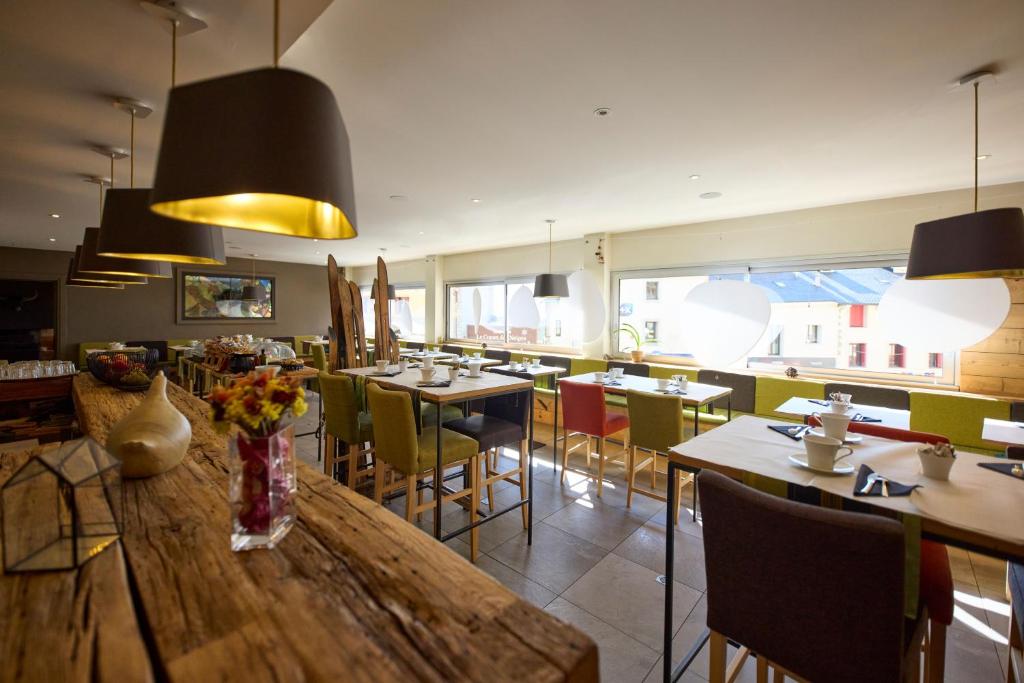 un restaurant avec une grande table et des chaises en bois dans l'établissement Hôtel Le Grand Tétras, à Font-Romeu