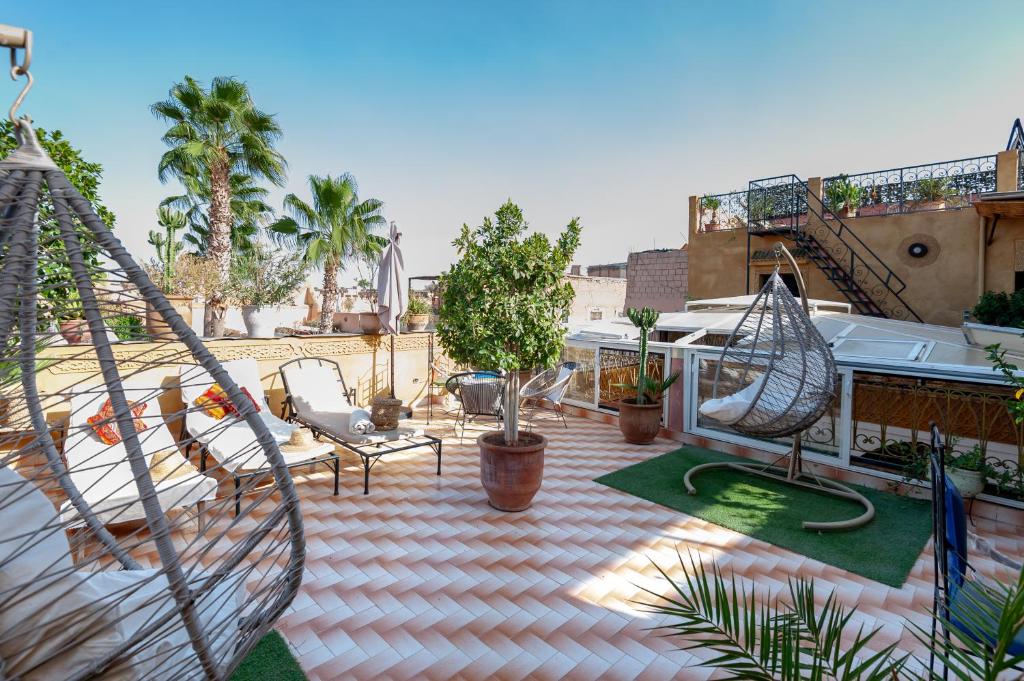 un patio avec un hamac et des chaises sur le toit dans l'établissement Riad Losra, à Marrakech