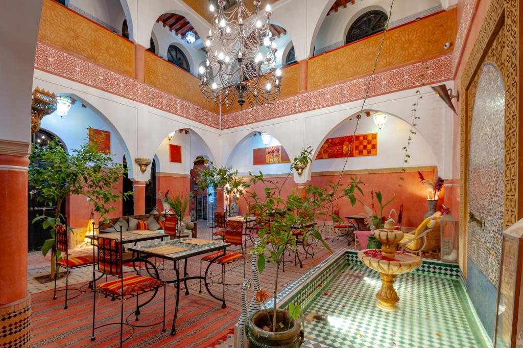 un restaurant avec une piscine au milieu d'une pièce dans l'établissement Riad Losra, à Marrakech